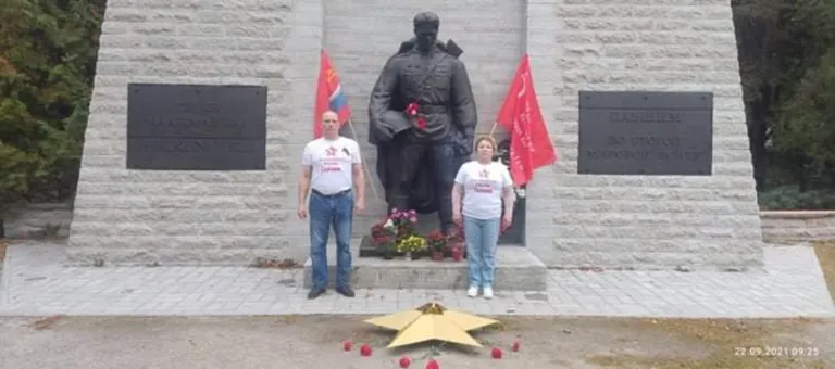 Чаулин и Палямар позируют перед бронзовым солдатом.