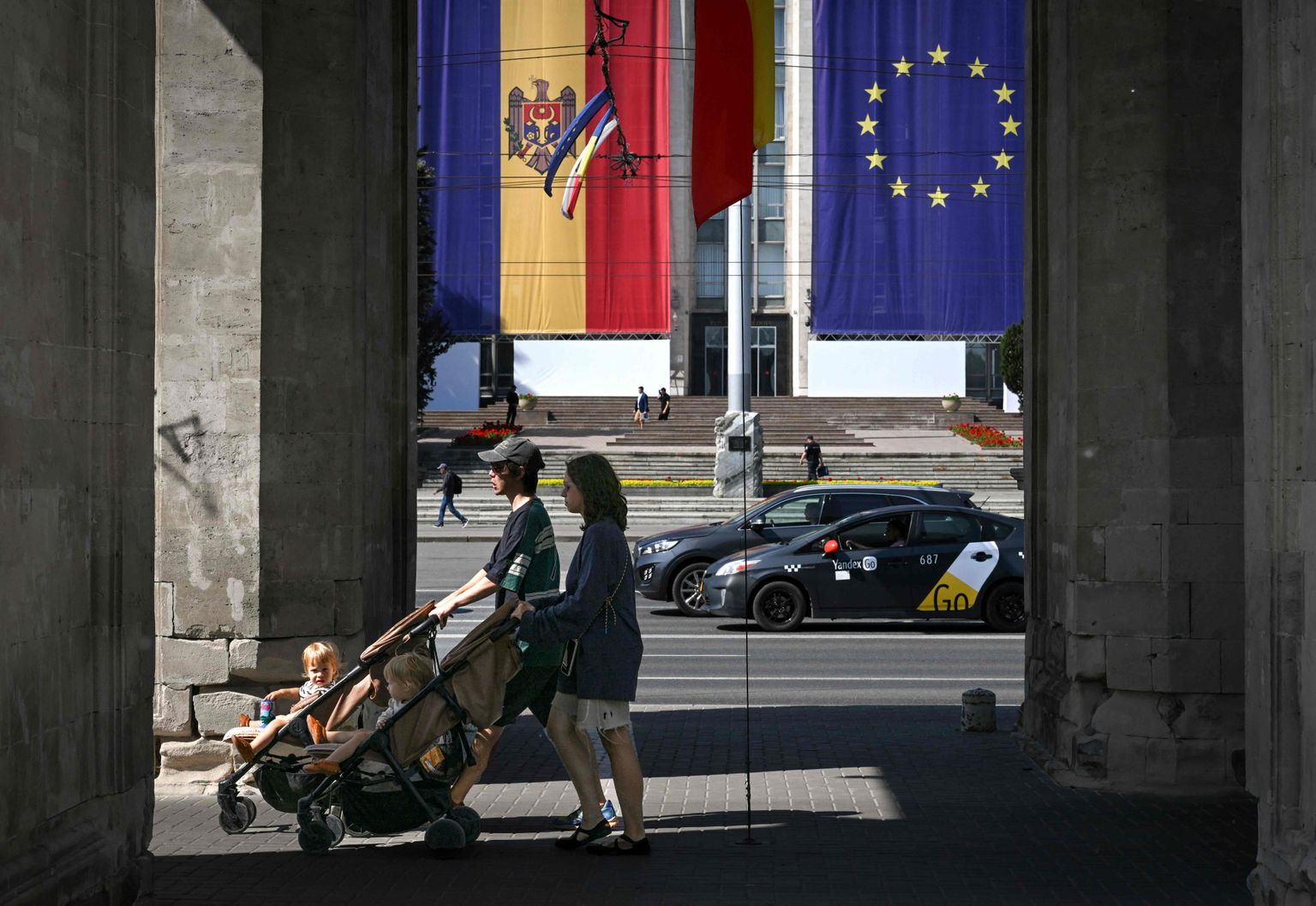 Chișinău elanikud mööduvad valitsushoonest, millel ripub Moldova ja ELi lipp.