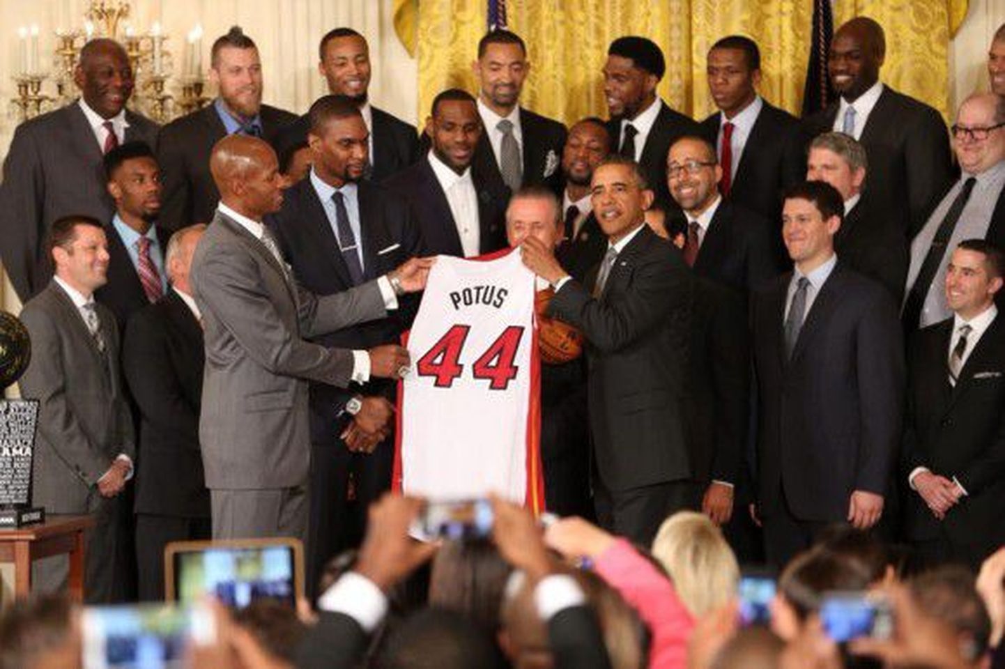 Президенту США Бараку Обаме вручают баскетбольную майку.