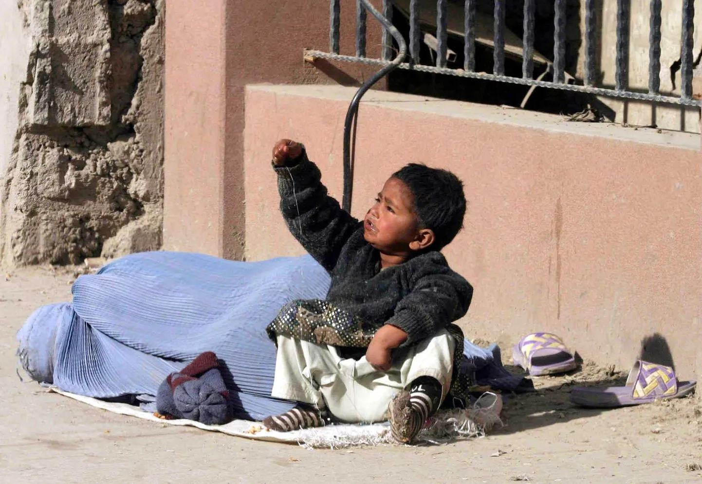 Afgaani poiss kerjusest ema kõrval. Just vaesust peetakse faktoriks, miks paljud lapsed selles riigis seksiorjusse sattuvad.
