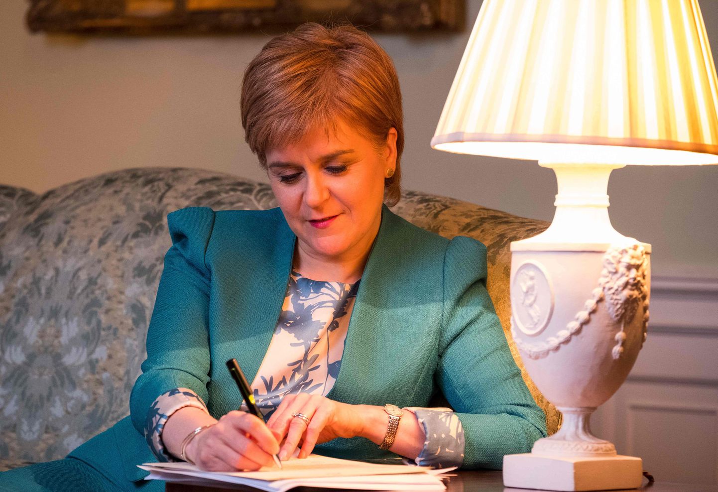 Šoti valitsuse avaldatud foto kirja allkirjastavast valitsusjuhist Nicola Sturgeonist.