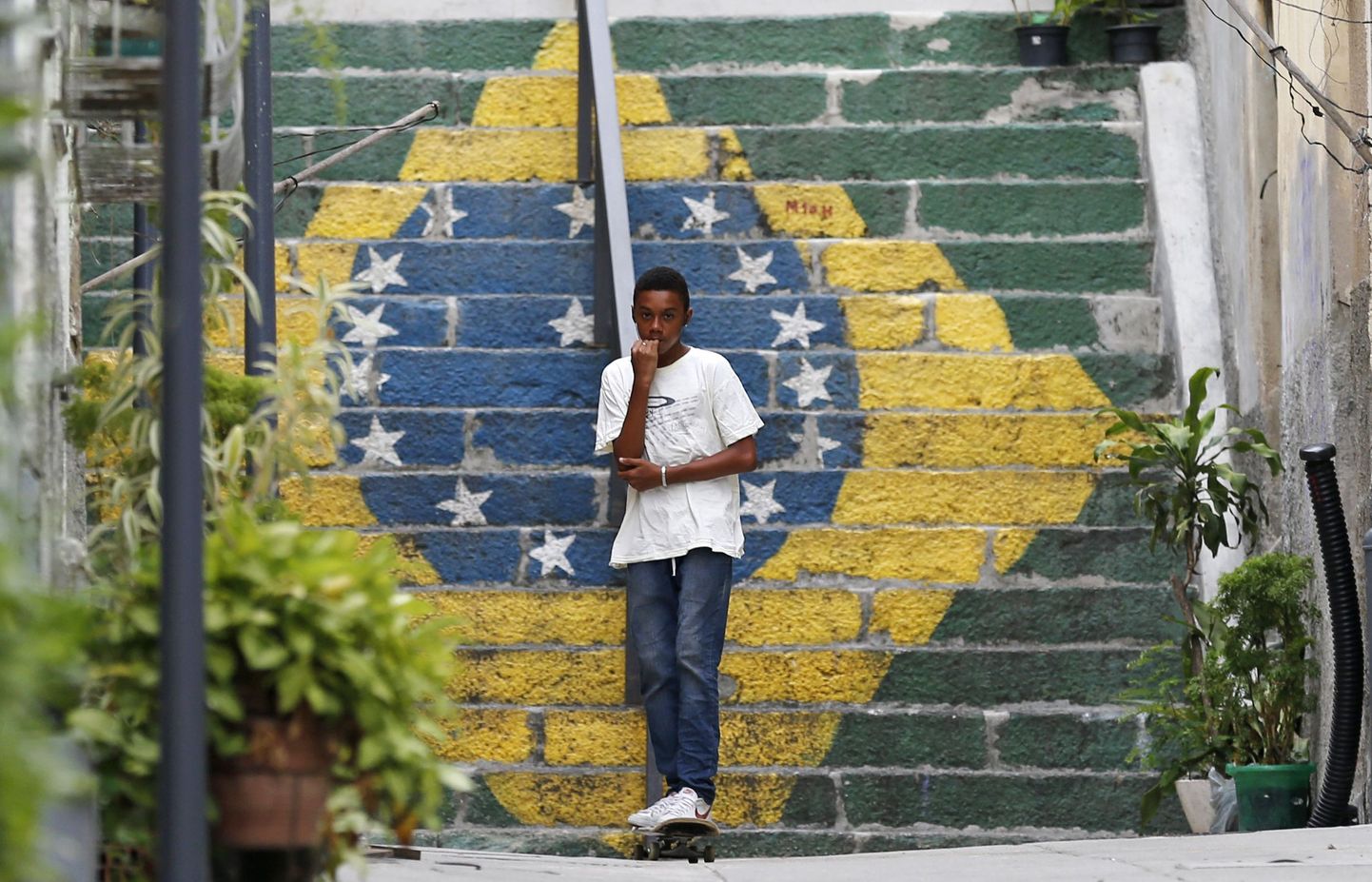 Rulaga poiss Rio de Janeiros Brasiilia lippu kujutava trepimaalingu taustal.