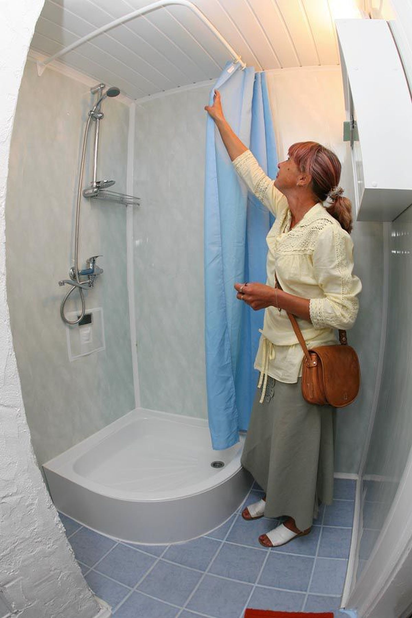 Mittetulundusühingu Singel Kodu juhatuse liige Lea Märtsin näitab remonditud vannituba, mis on küll tagasihoidlik, kuid puhas ja valge.