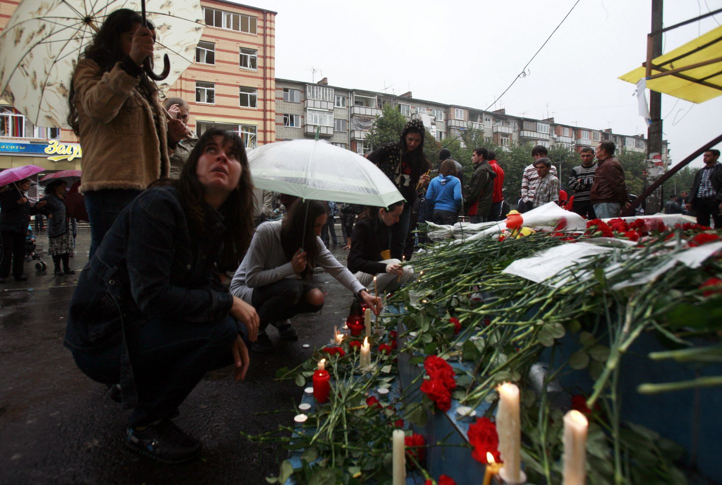 Люди возлагают цветы к месту теракта, совершенного во Владикавказе.