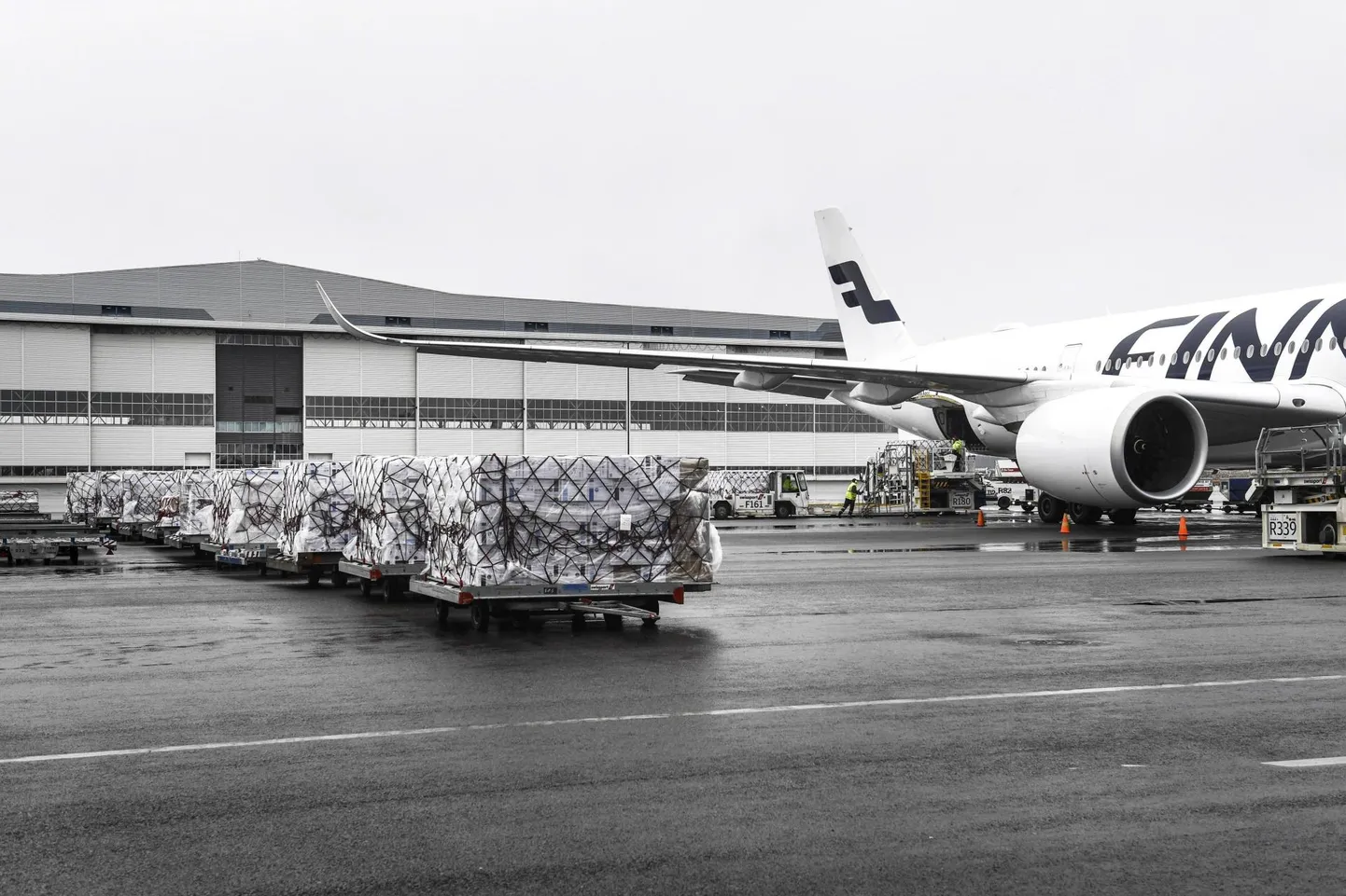 Töölised Helsinki-Vantaa lennujaamas Finnairi kaubalennukiga Hiinast saabunud meditsiinivarustust maha laadimas.