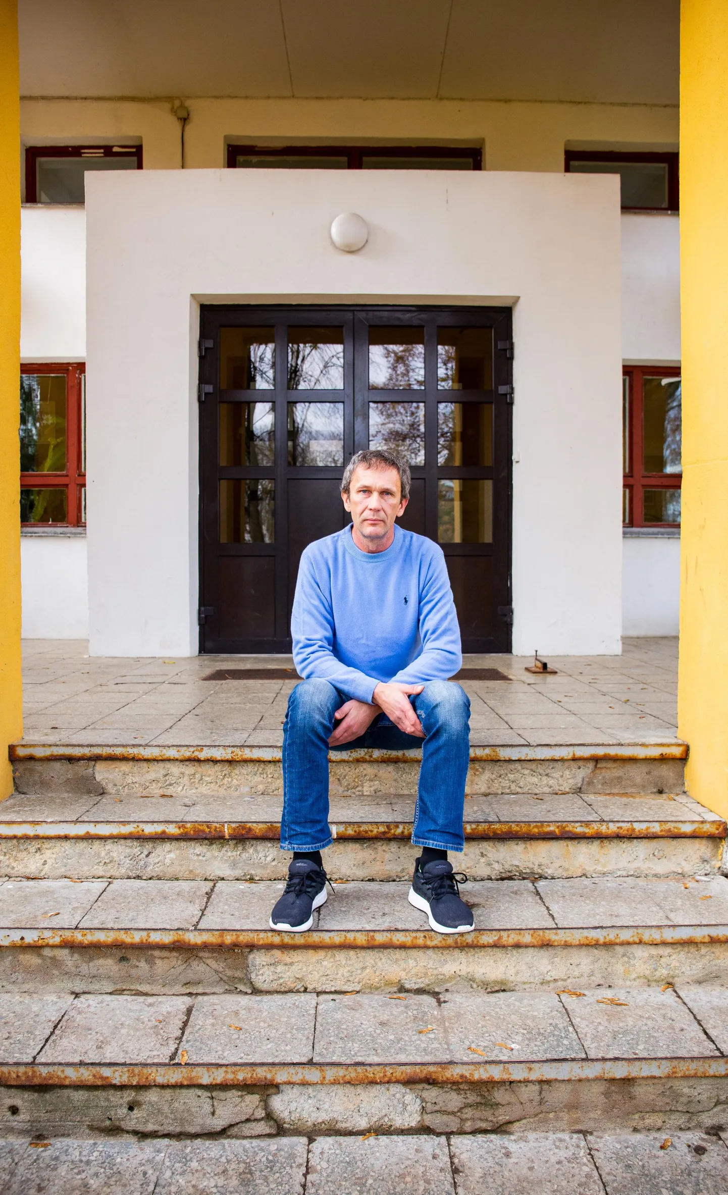 Ivo Tupitsal on Haljala kooli juhtides tulnud silmitsi seista erinevate väljakutsetega – nii koroonaajaga kui ka uue koolimaja ehituse ja sellega kaasnenuga. Nüüd on väljakutseks õpetajate streik. Pildil istub koolijuht Haljala vana koolimaja trepil.