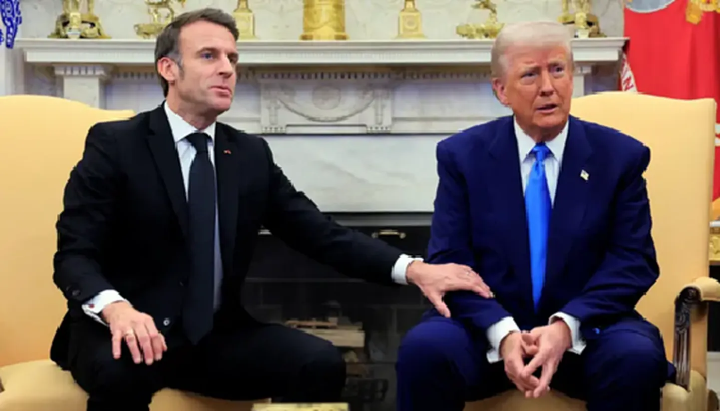 Эммануэль Макрон трогает Дональда Трампа за руку во время совместной пресс-конференции.