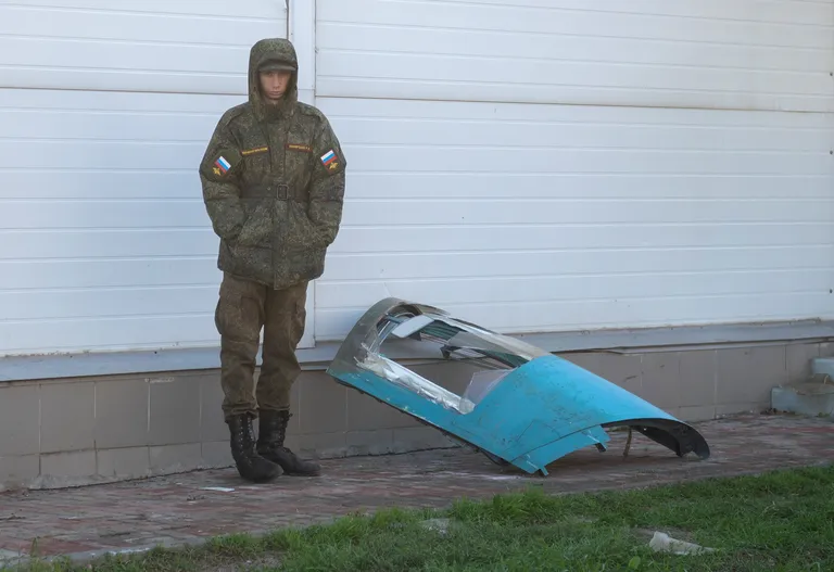 Российский военнослужащий охраняет фрагмент бомбардировщика Су-34, разбившегося в жилом квартале в городе Ейск, Россия, 18 октября 2022 года.