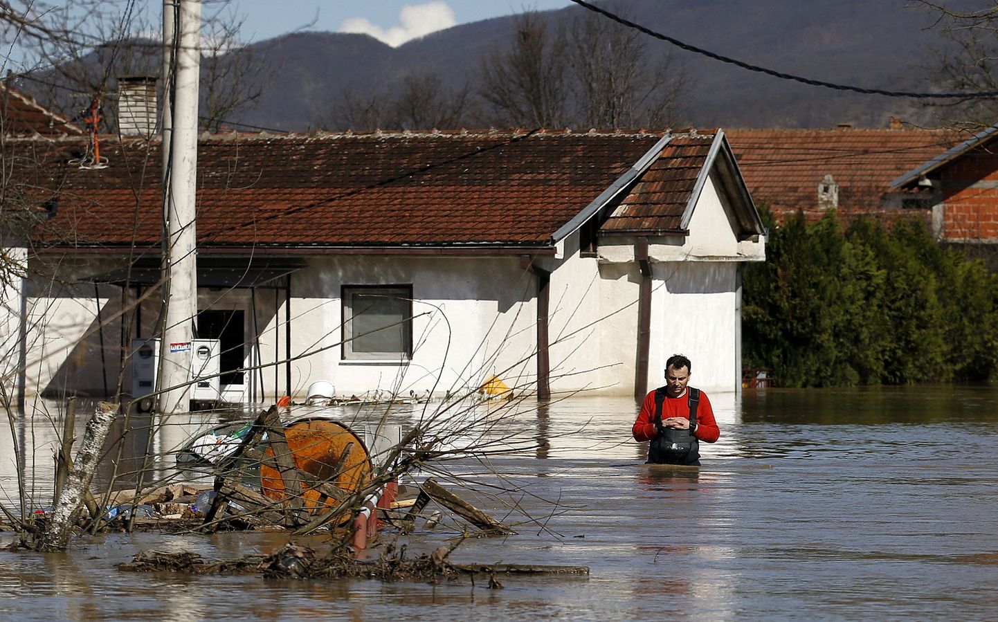 A man walks in front of a his flooded home in the village of Grdica, Serbia, Tuesday, March 8, 2016. Hundreds of people had to evacuate their homes, while hundreds of houses remained under threat, police said. In several villages and towns, entire areas have been left without electricity or water, and some schools canceled classes for the day. (AP Photo/Darko Vojinovic)