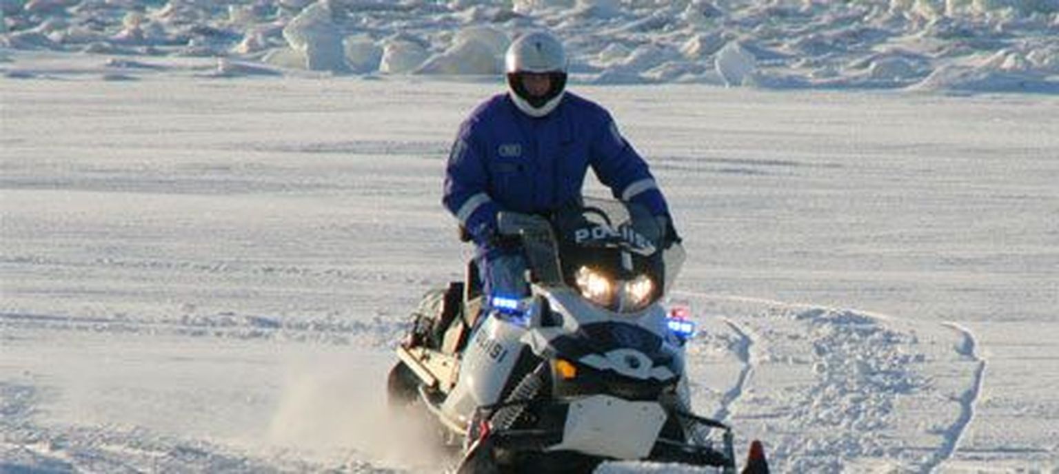 Mootorsaaniga ringi liikuv politseinik Soomes.