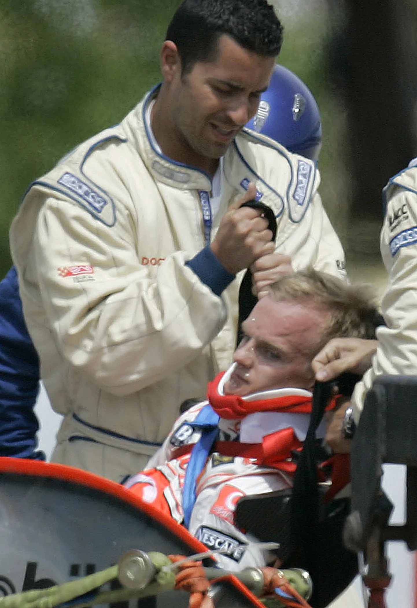 Heikki Kovalainen tõstetakse purunenud masinast välja..
