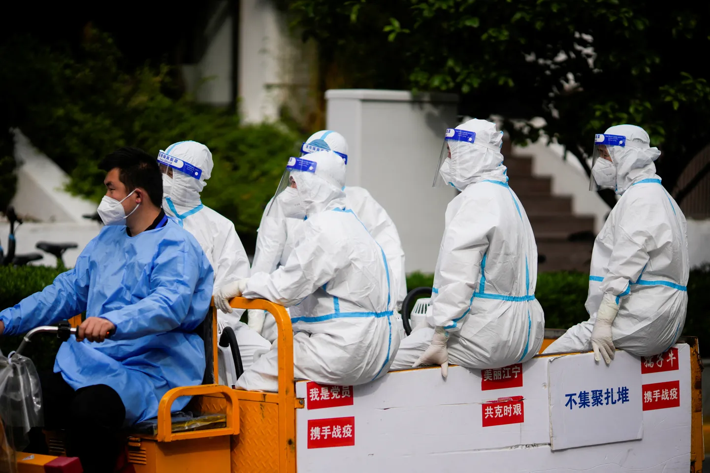 Kaitseülikondades töötajad Shanghai tänavatel.