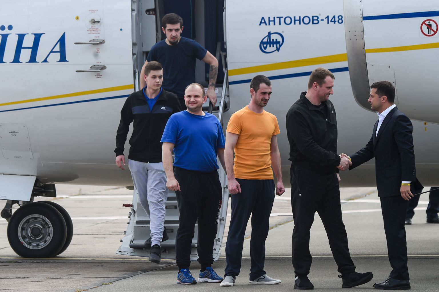 Ukraina president Volodõmõr Zelenskõi tervitab Kiievi lennuväljal vabastatud vange.