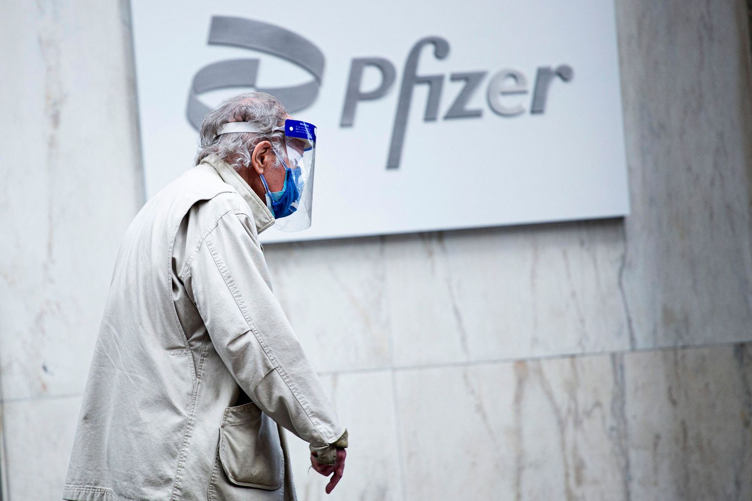 Kahe maski ja visiiriga vanainimene möödumas Pfizeri peakorterist New Yorgis 2021. aasta 11. märtsil.