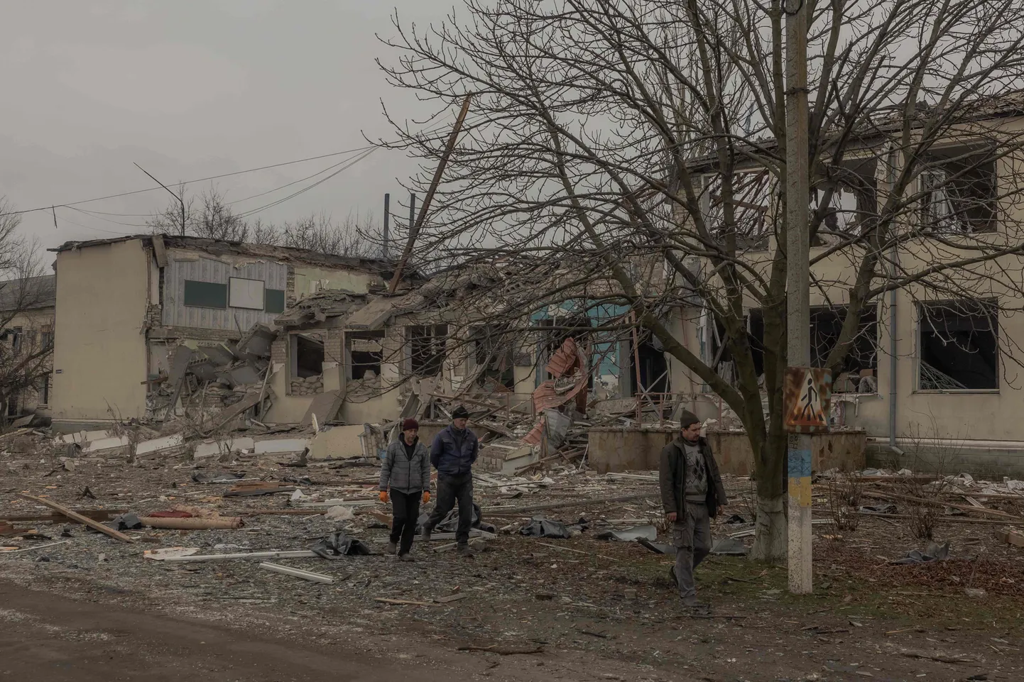 Люди возле недавно разрушенного в результате российского удара школьного здания в Новопавловке, Днепропетровская область.