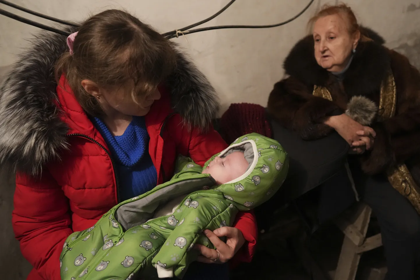 Naine hoidmas Ukraina pommitamise ajal magavat last.