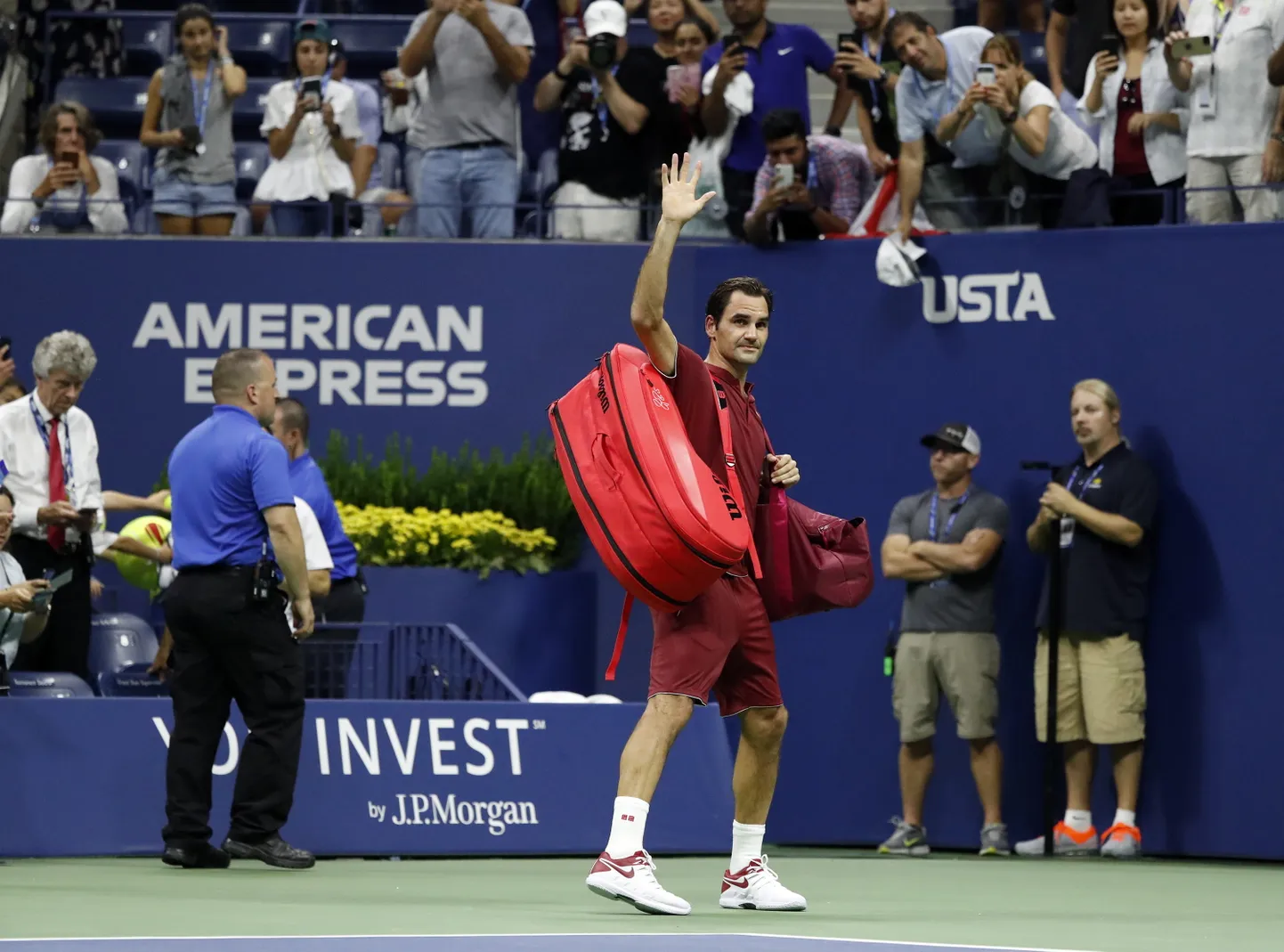 Roger Federer of Switzerland (C) waves to the crowd as he walks off court after losing his match against John Millman of Australia during the eighth day of the US Open Tennis Championships at the Arthur Ashe Stadium in the USTA National Tennis Center in Flushing Meadows, New York, USA, 03 September 2018. The US Open runs from 27 August through 09 September.  EPA/JASON SZENES