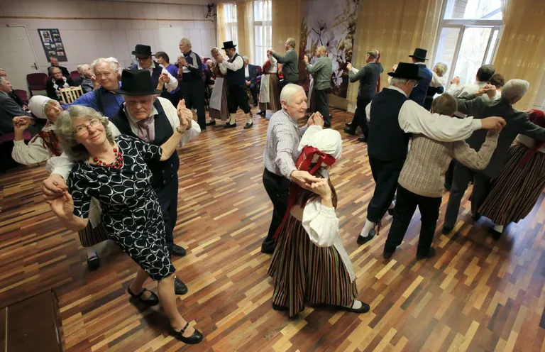 Kusta rahvatantsurühma tantsijad koos publikust leitud vilistlastantsijatega.