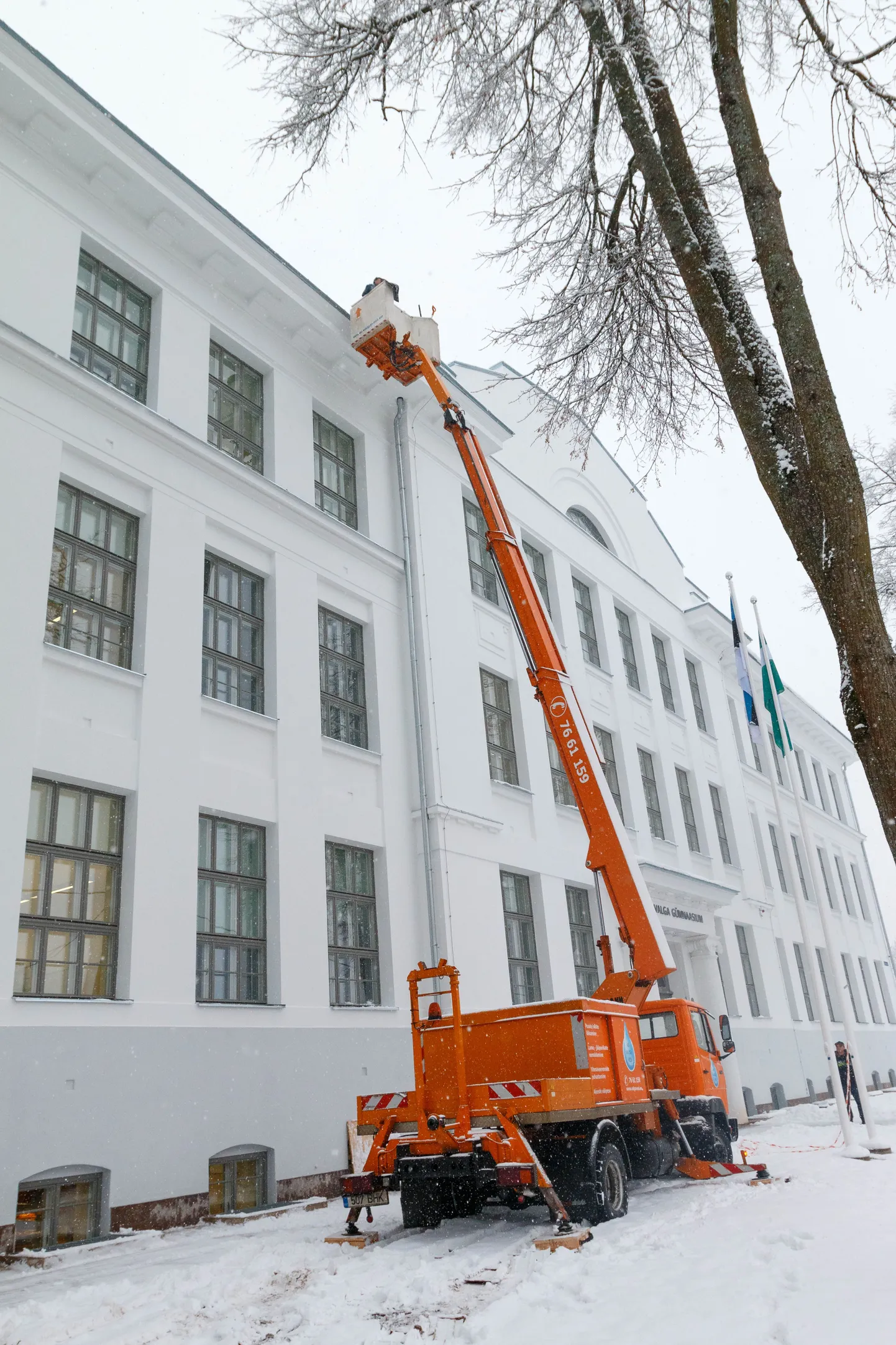Valga gümnaasiumi katuselt eemaldati eile hommikul varisemisohtlik jää ja lumi tõstuki abiga. Enne seda piirasid ala hoituslindid.