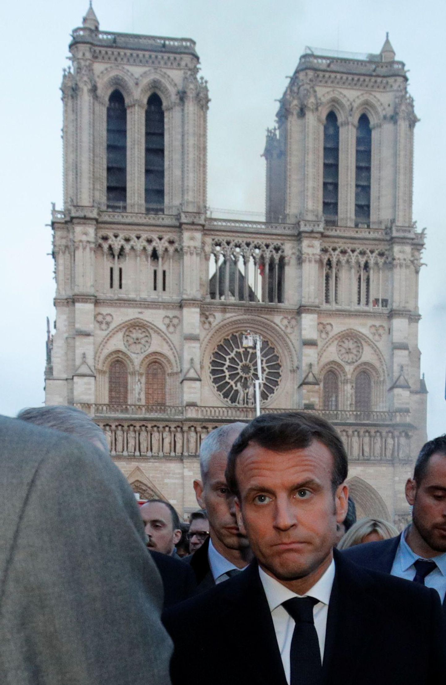Prantsuse president Emmanuel Macron teisipäeva hommikul suitsevate Jumalaema kiriku varemete juures. 