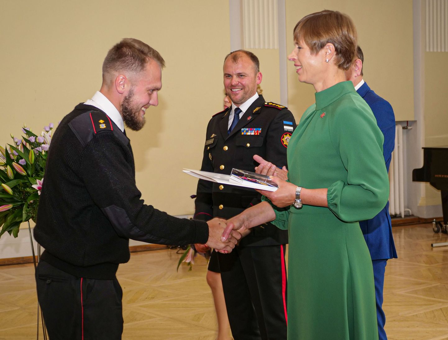 KÄEPIGISTUS PRESIDENDILT: Mihkel Rauale annab aumärgi üle president Kersti Kaljulaid, tagaplaanil rõõmustab päästeameti peadirektor Kuno Tammearu.