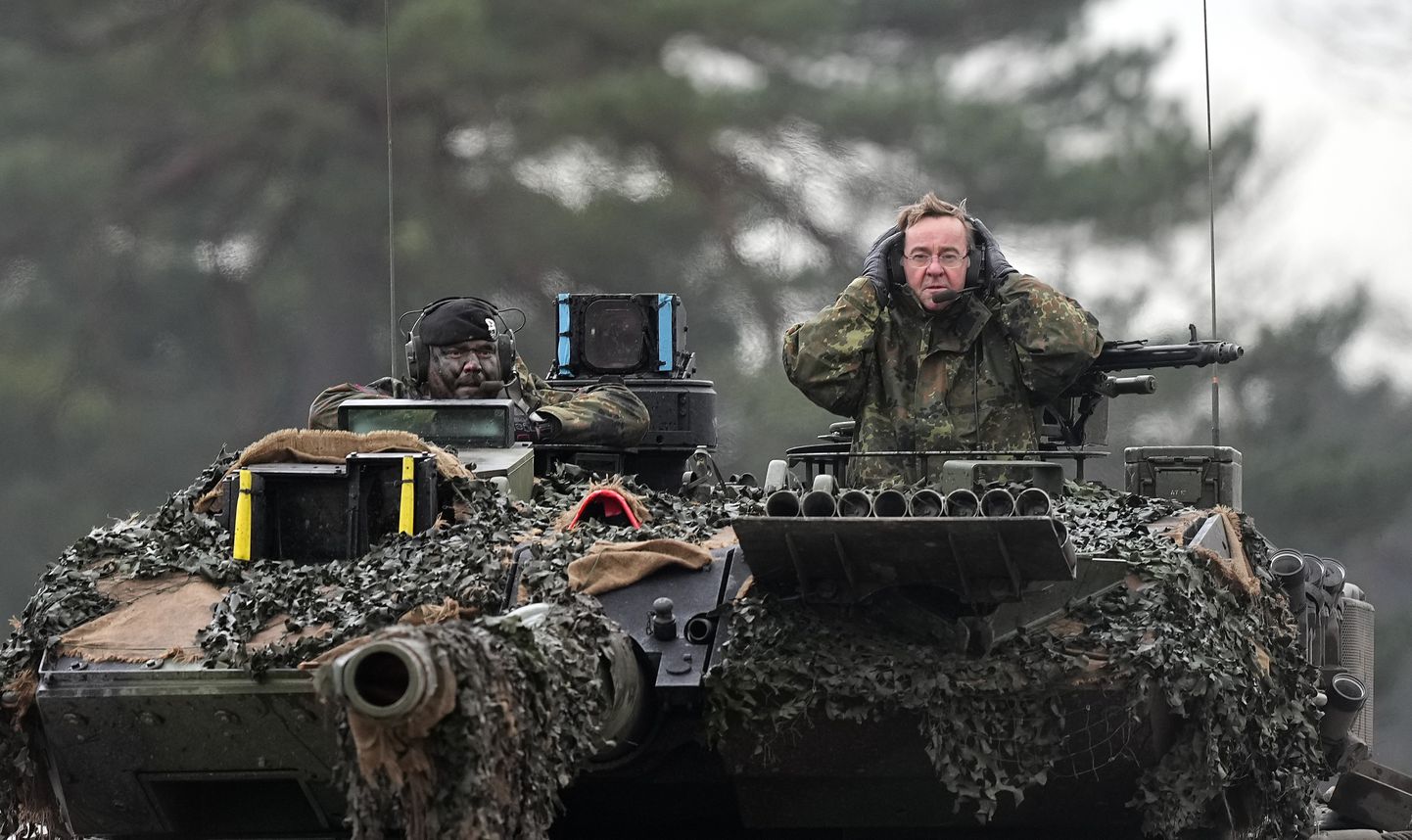 German Defense Minister Boris Pistorius, right, sits on a Leopard 2 tank at the Bundeswehr tank battalion 203 at the Field Marshal Rommel Barracks in Augustdorf, Germany, Wednesday, Feb. 1, 2023.