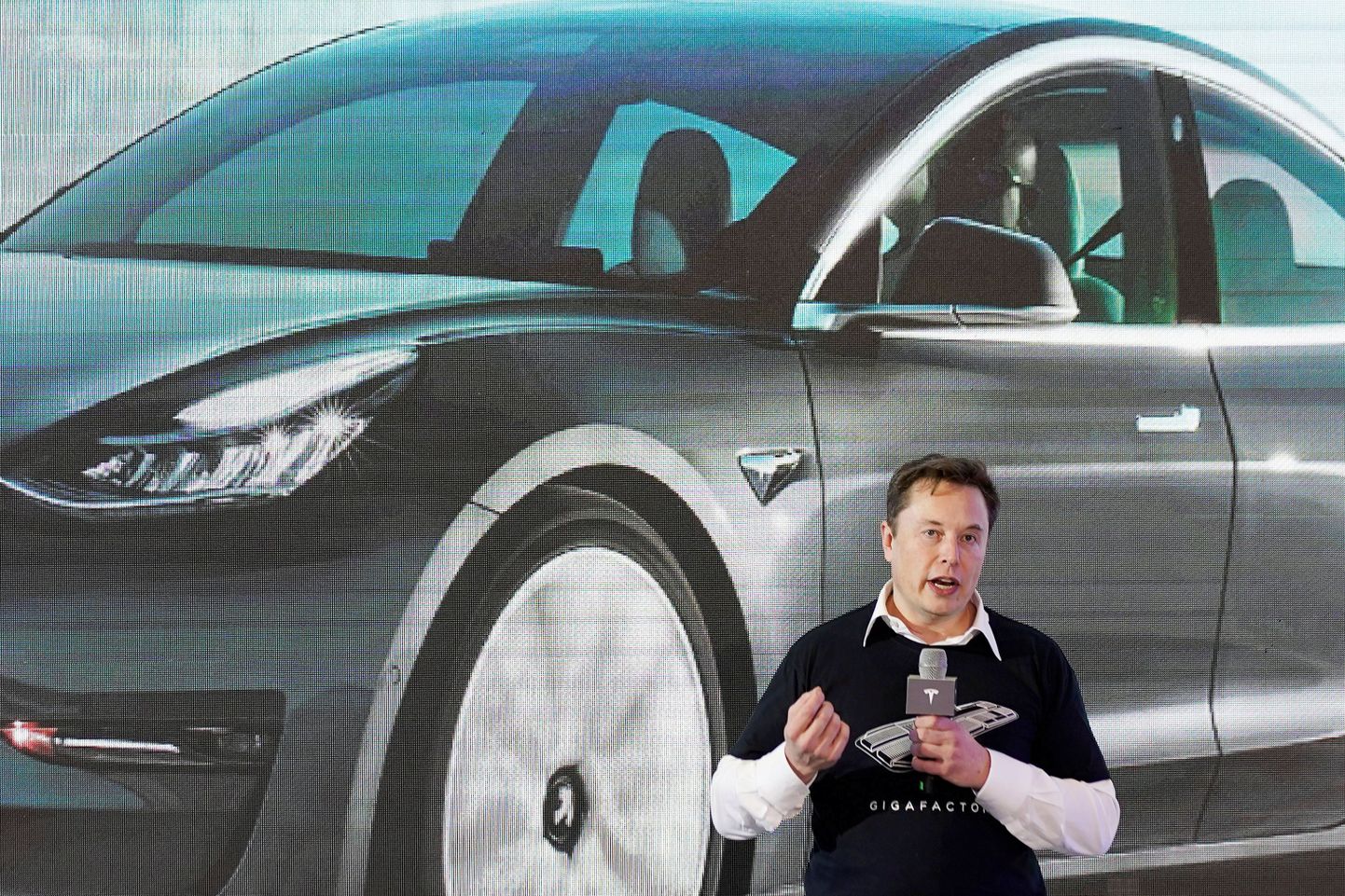 Tesla juht  Elon Musk Hiinas valmistatud Model 3 juures kõnet pidamas.