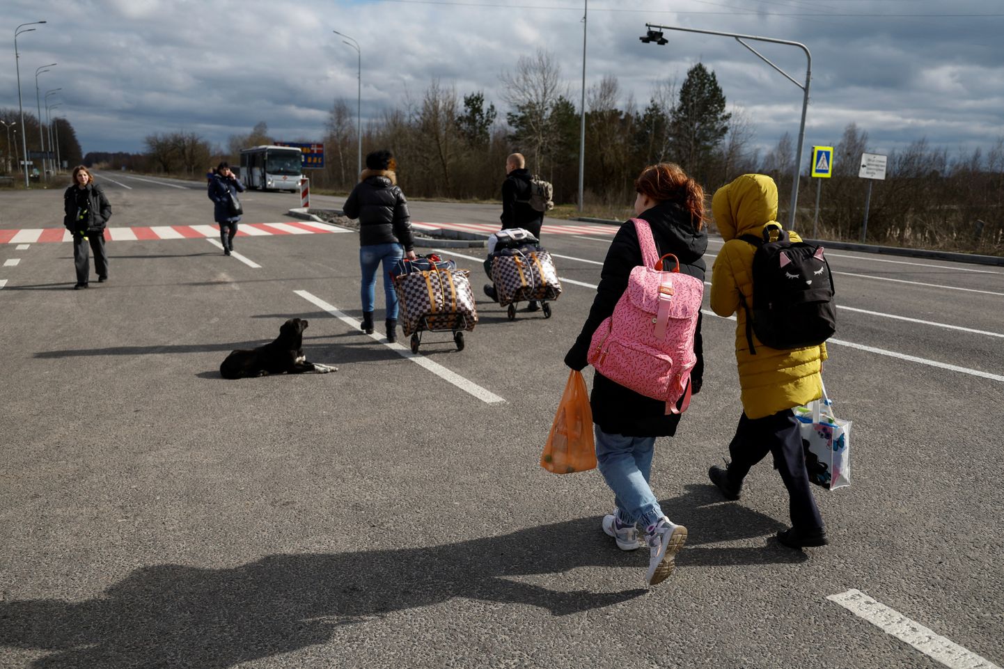 Sunniviisiliselt okupeeritud aladelt Venemaale viidud ukraina lapsed kõnnivad taas kodumaale jõudnuna bussi suunas Valgevene-Ukraina piiri lähistel