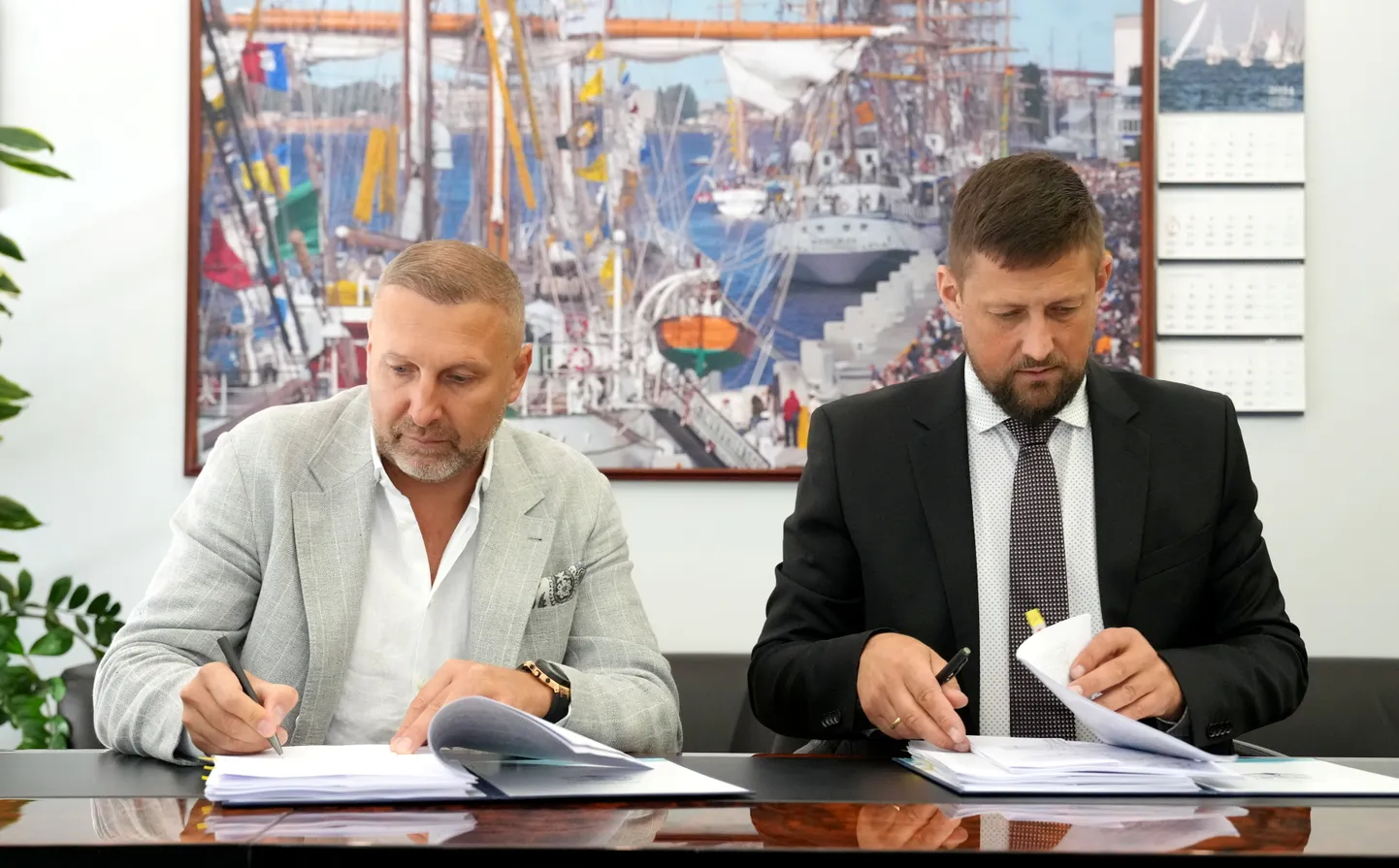 Lietuvas uzņēmuma "SNG Solar" ģenerāldirektors Sergei Badulia (no kreisās) un Rīgas brīvostas pārvaldnieks Ansis Zeltiņš paraksta līgumu par saules paneļu parka izveidi Rīgas ostas Spilves pļavu teritorijā.