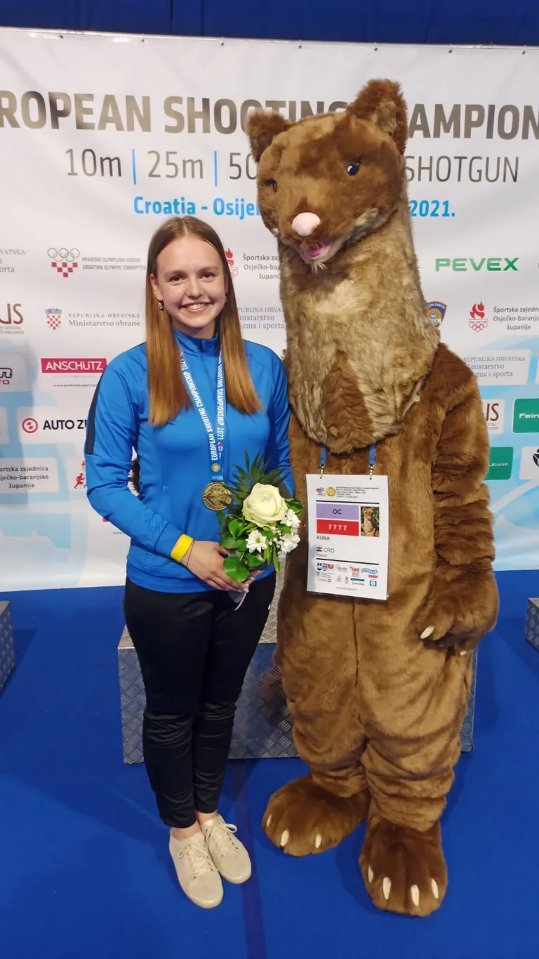 Катрин Смирнова с юниорской золотой медалью и рядом с талисманом чемпионата Европы по стрельбе в хорватском Осиеке.