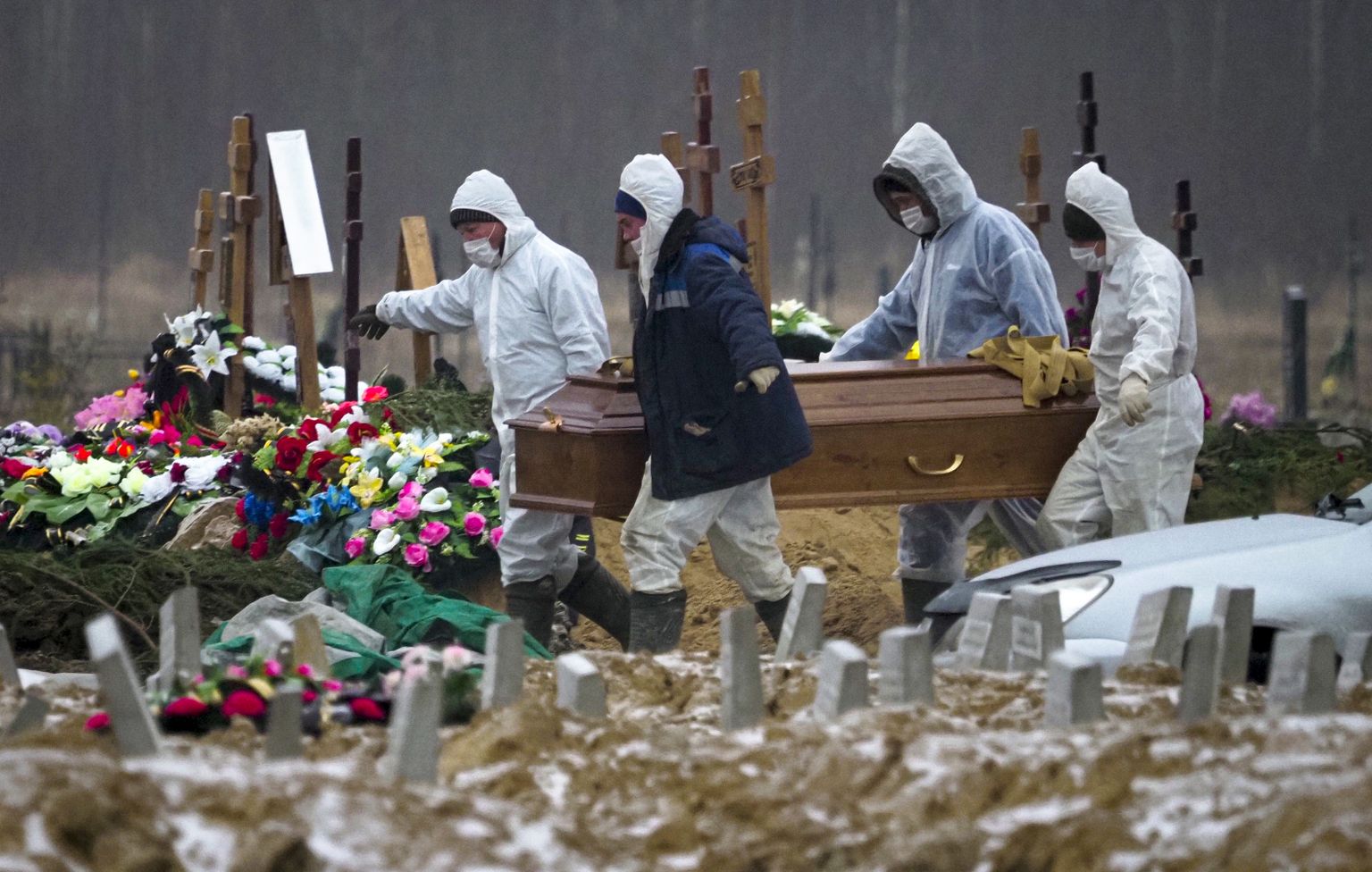 Venemaal Peterburi lähedal Kolpinos asuv surnuaed. Pildil matmispaiga kaitseülikondades töötajad kandmas viirushaiguse Covid-19 tõttu surnud inimese kirstu haua juurde