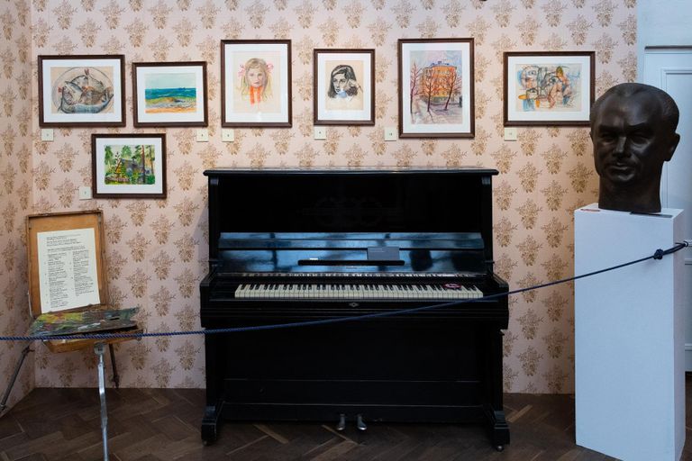 Tapetseeritud toanurk laulja ja näitleja pianiino, molberti ja joonistustega.