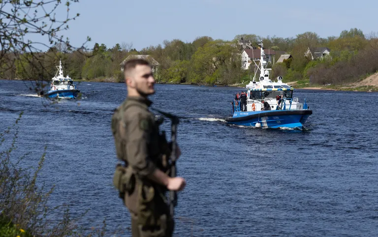 Сотрудник PPA дежурит на берегу Наровы во время перемещения вдоль границы с Россией пограничных катеров с президентами Эстонии и Исландии на борту. Речная прогулка Алара Кариса и Гвюдни Йоуханнессона состоялась ровно за неделю до инцидента, когда сотрудники ФСБ демонтировали и увезли световые буи Эстонии.