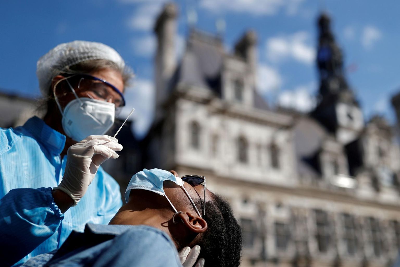 Tervishoiutöötaja tegemas koroonatesti Pariisi linnavalitsuse hoone ees. 
