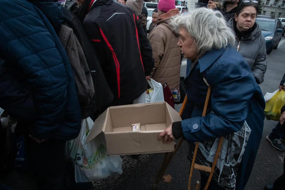 Karkudega naine lükati toidujagamisel teiste selja taha.
