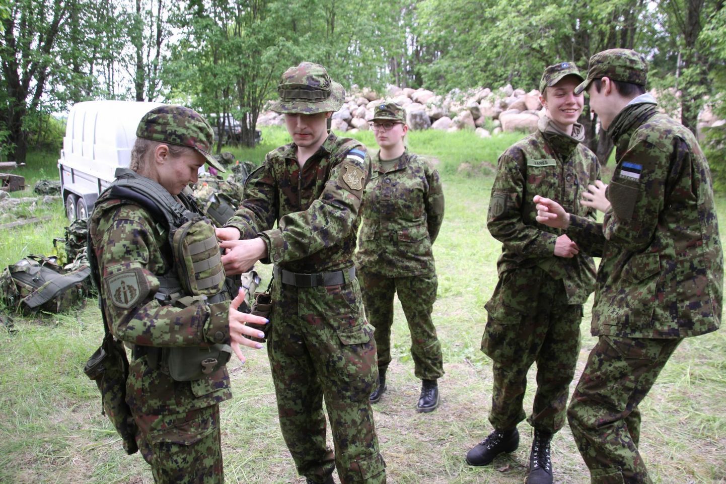 Paide gümnaasiumi õpilane Krislin Virkoja (vasakul) soovis proovida kaitseväelase kuulivesti, mida kaitseväe akadeemia kadett Toomas-Hendrik Ojapere aitab tal selga panna.