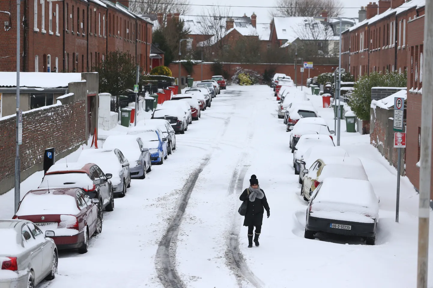 Naine jalutamas lumme mattunud tänaval Dublinis.