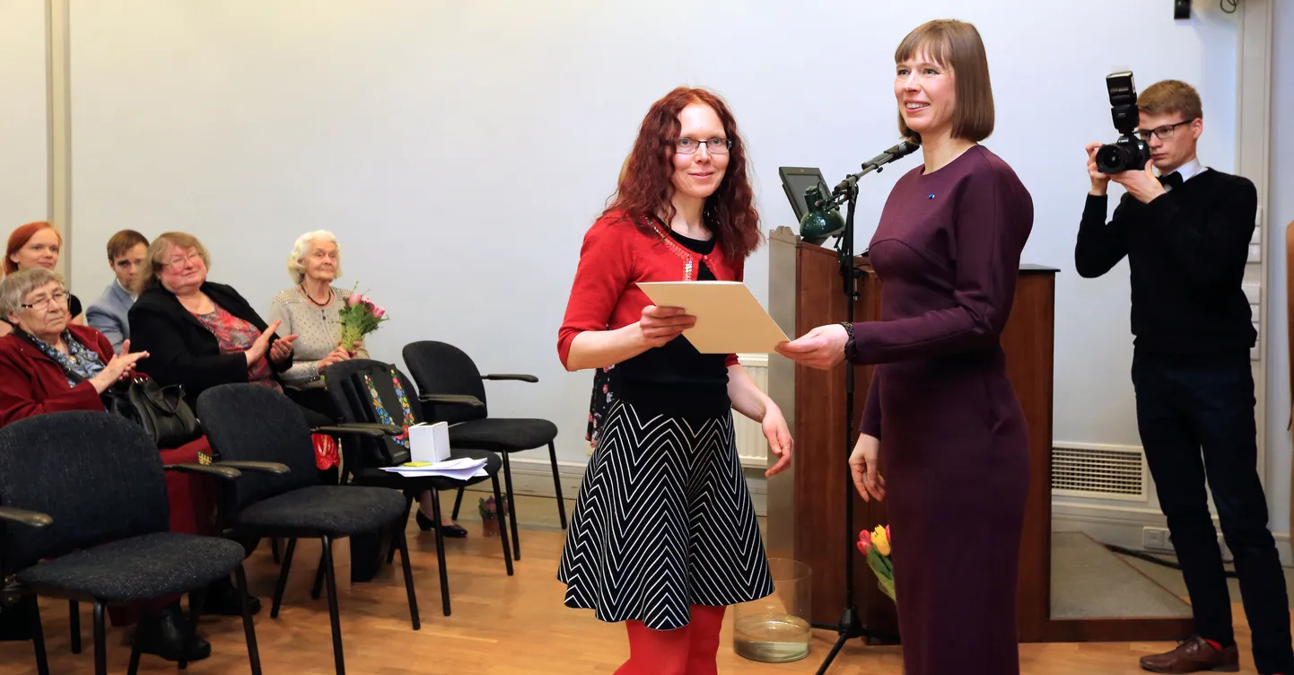 President Kersti Kaljulaid õnnitleb rahvaluule 
kogumispreemia pälvinud Merili Metsvahit.