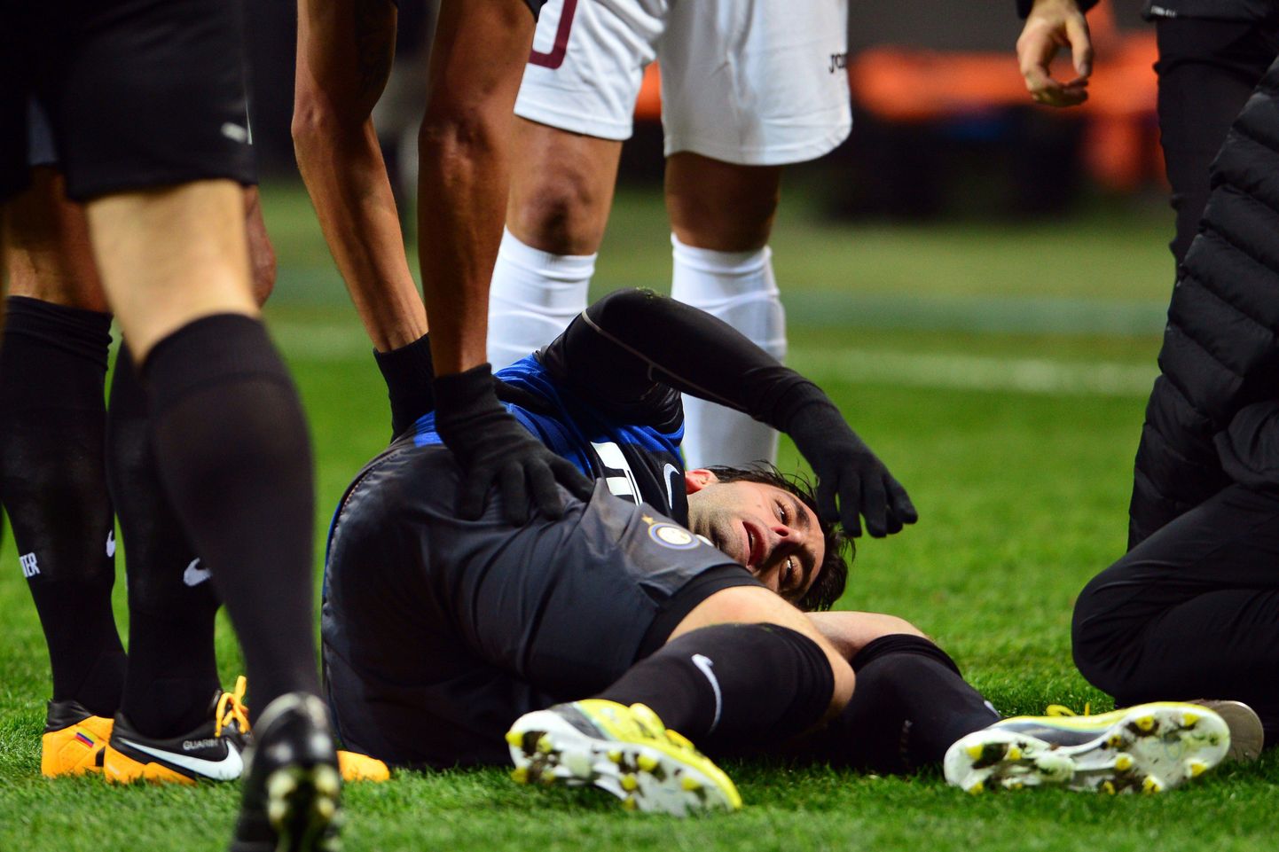 Диего Милито лежит на поле после получения травмы.