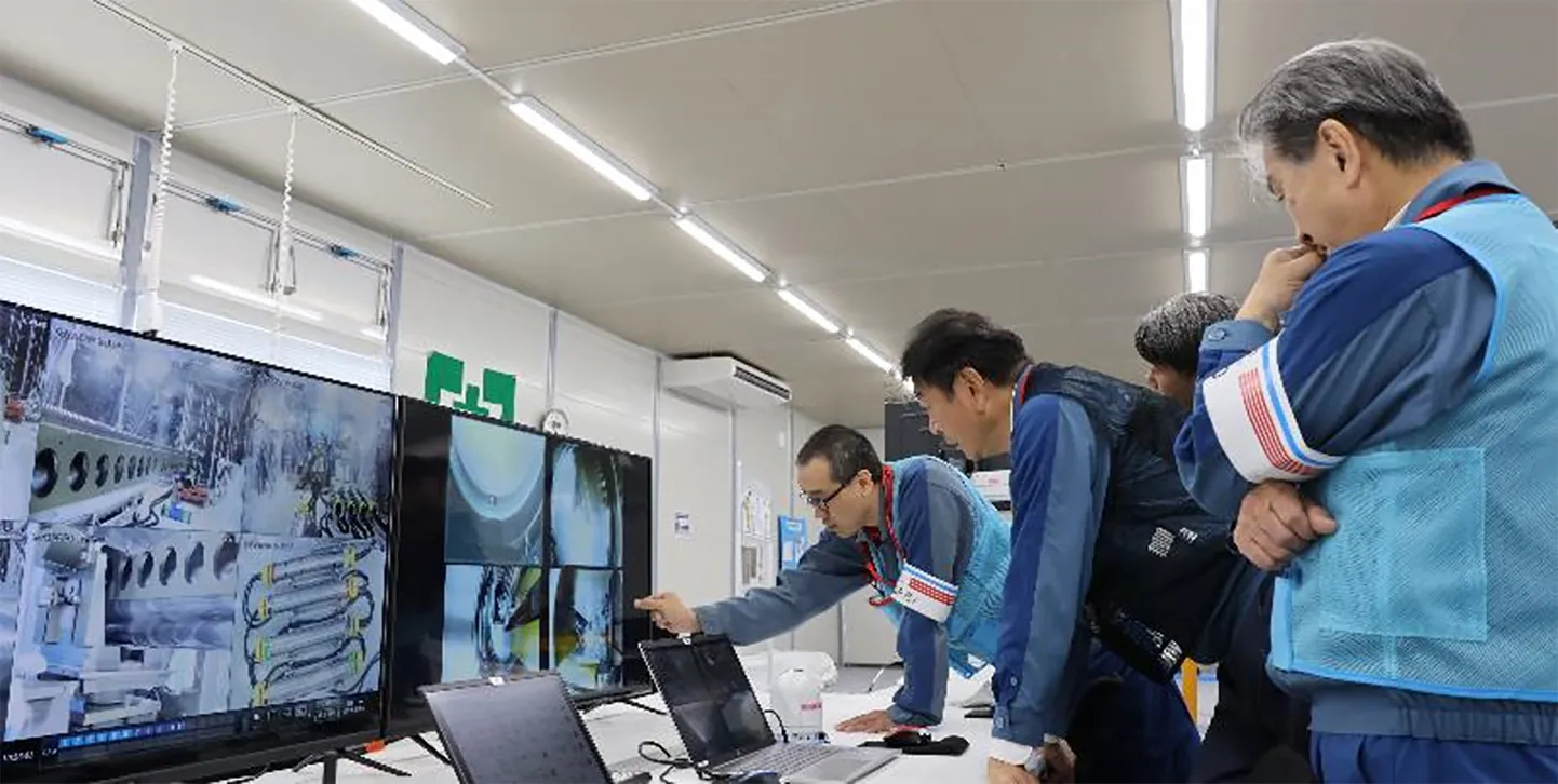 Fukushima tuumaelektrijaama operaatorfirma Tokyo Electric Power Company (TEPCO) juhtkonna liikmed jälgivad tuumajaama ametnike viimaseid ettevalmistusi ja protseduurilist kontrolli enne kaugjuhitava robotiga tegutsema asumist. Foto on tehtud 9. septembril.