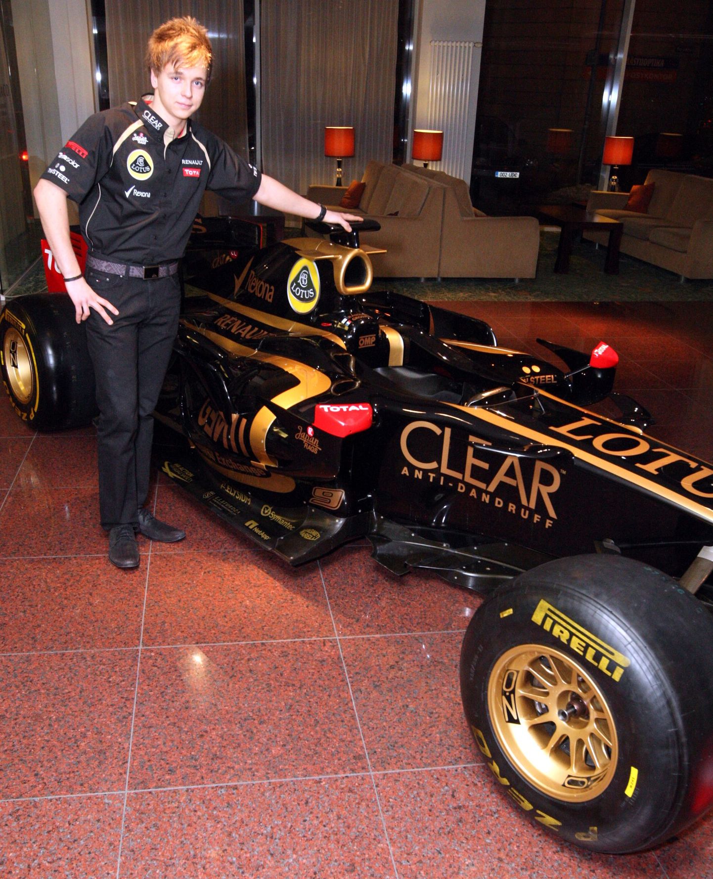 Кевин Корьюс на фоне болида команлы Lotus.