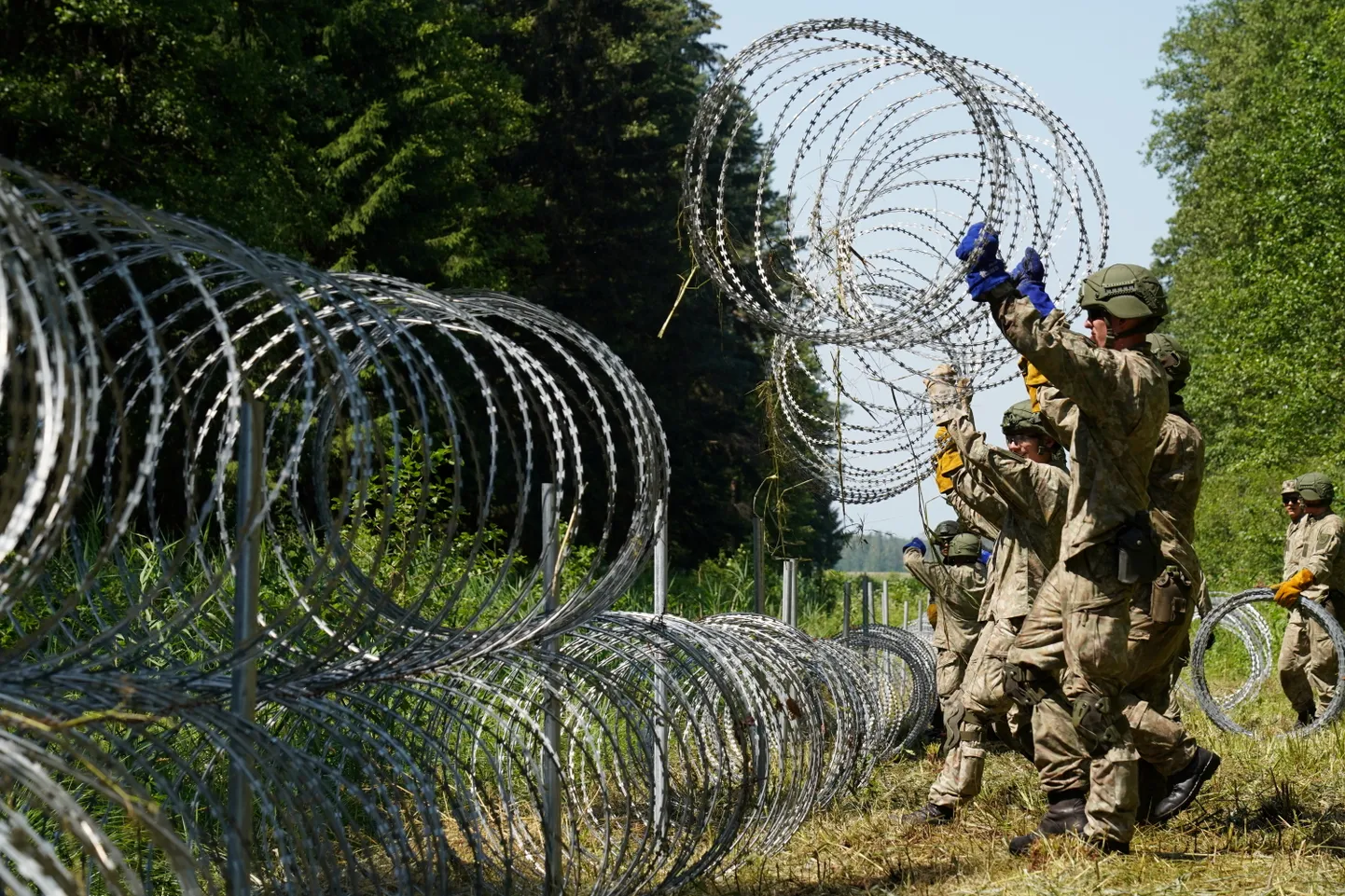 Литовские военные устанавливают заграждение.