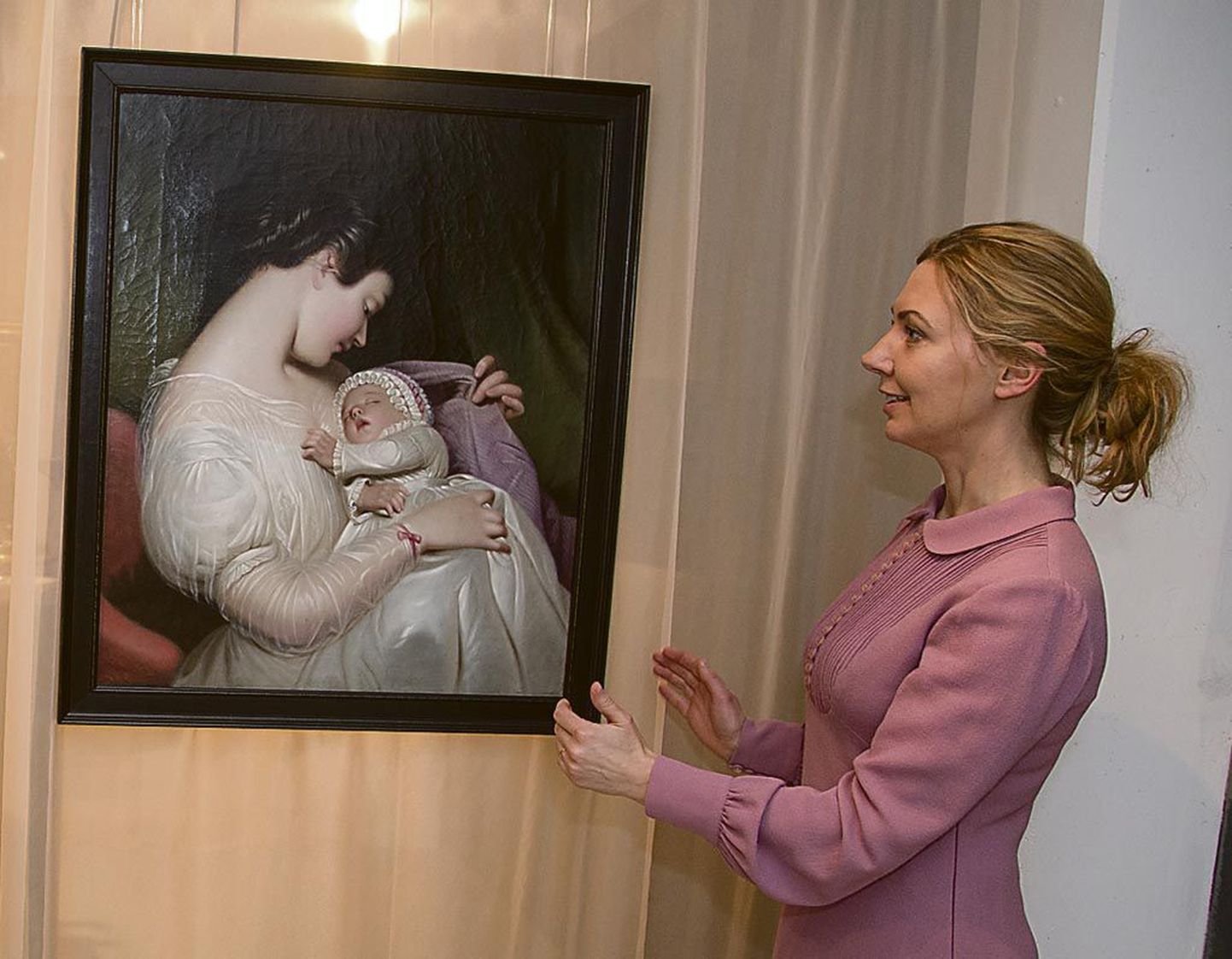 Kuraator Tiina-Mall Kreem näitab väljapaneku “Hoolitseva armastuse” osas tundmatu Saksa autori maali “Noor ema” (19. sajandi keskpaik). Kõik kunstiteosed kuuluvad Kadrioru kunstimuuseumi kogusse.