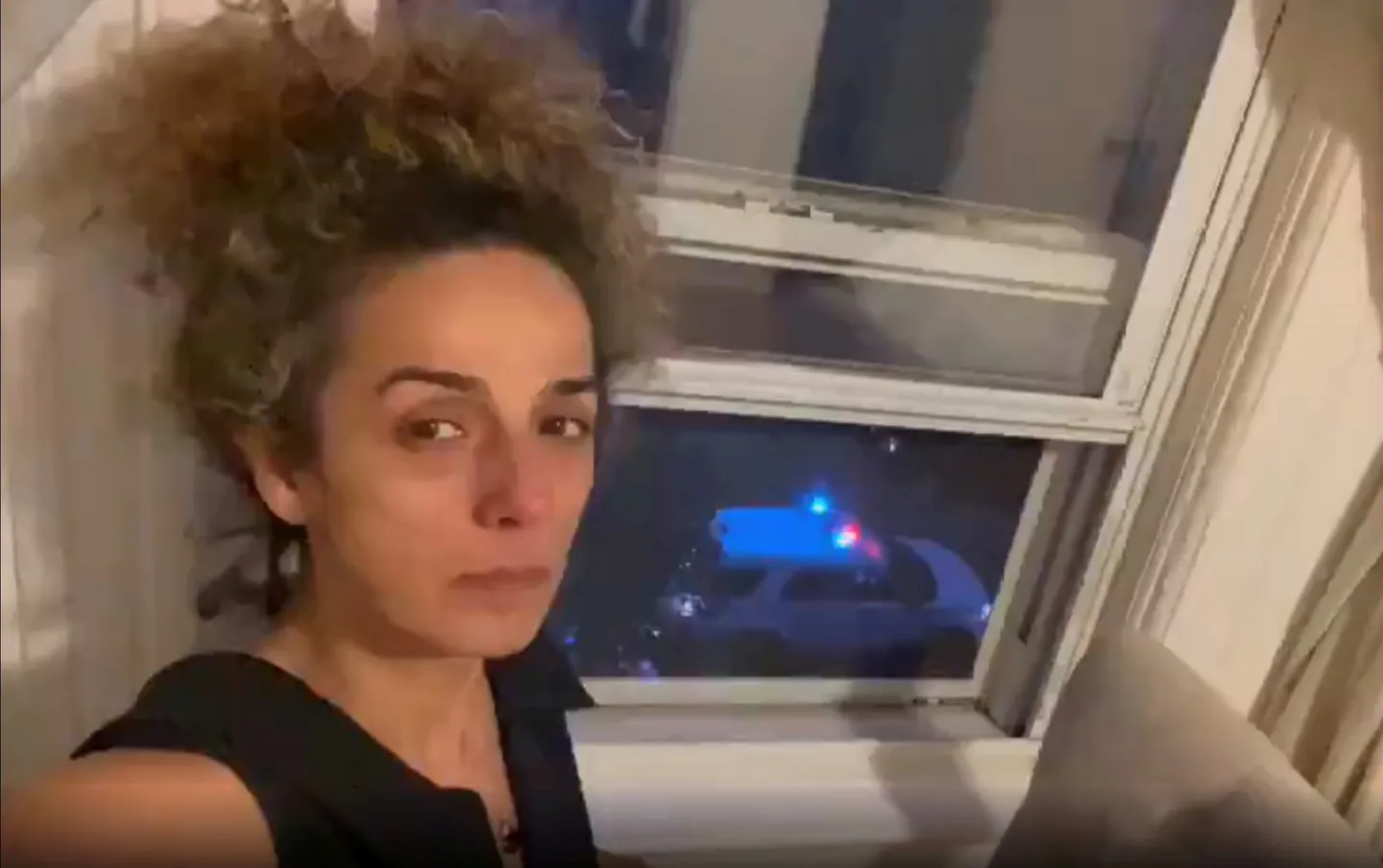 Alinejad Masih näitab läbi akna teda turvama sadetud politseimasinat.