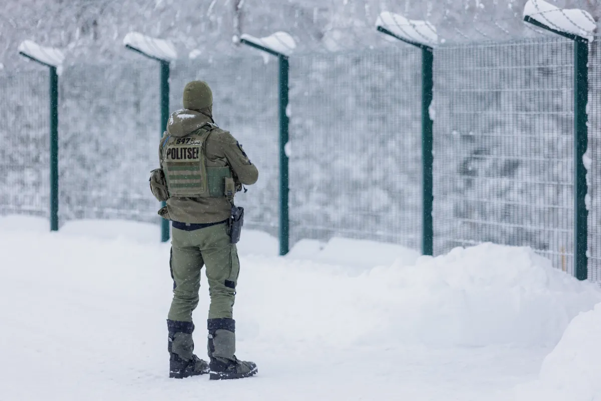 An Estonian Border Guard stands next to the newly built border fence on the southeastern border with Russia.