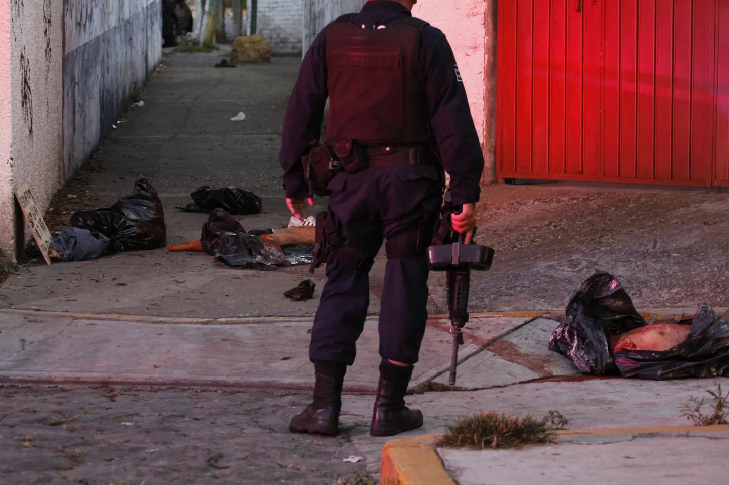 Sünge kaader 2012. aasta veresaunast Mehhikos. Politsenik seisab keset elurajooni, kus tapeti narkojõugu Guerreros Unidos liikmeid.