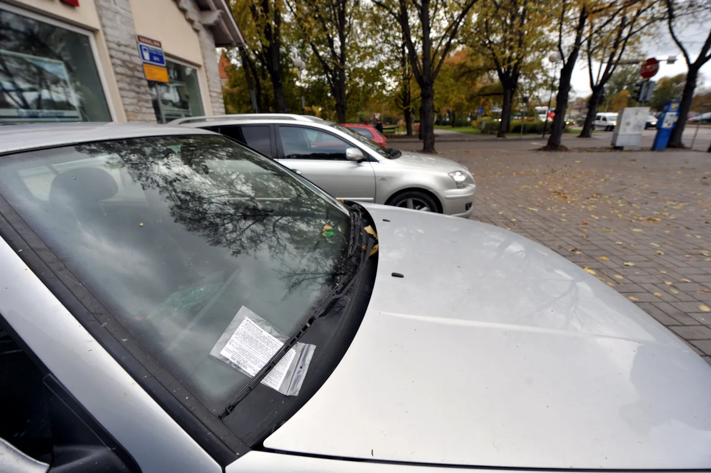 Parkimistrahvi kviitung auto esiklaasil.