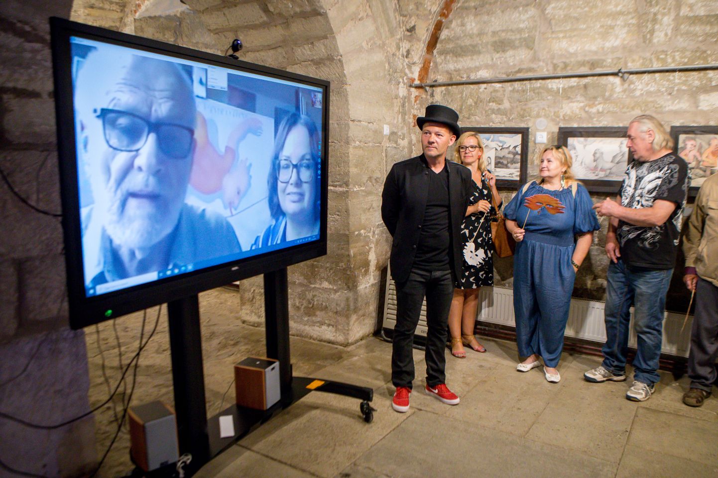 SIIN- JA SEALPOOL EKRAANI: Näituse korraldaja Taniel Vares (keskel) sai rahuloluga tõdeda, et kunstnik Jüri Arrak õnnestus Skype'i vahendusel oma ateljeest otse lossikeldrisse tuua.