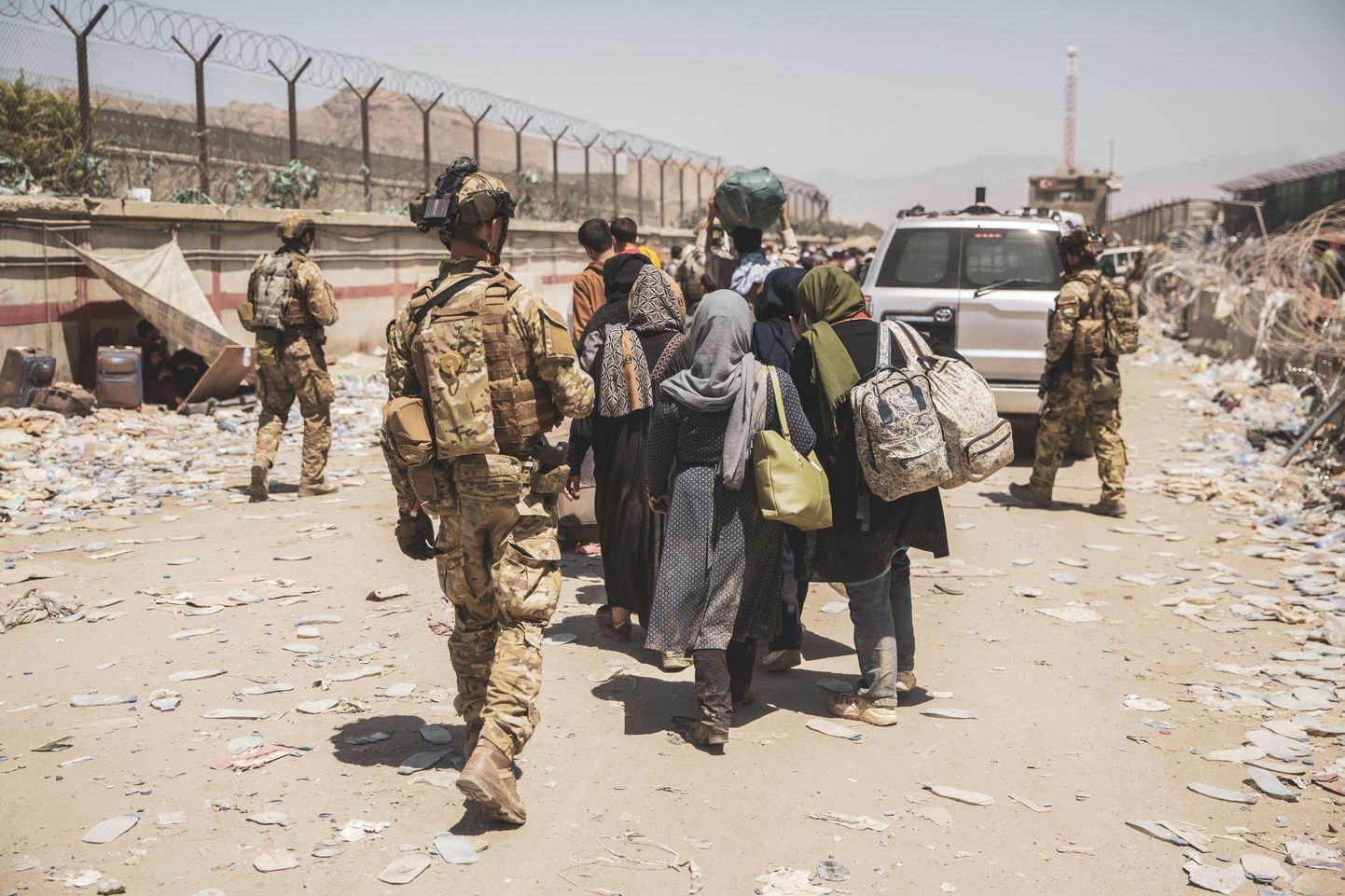 Itaalia sõdurid abistamas evakuaitsioonilennule suunduvaid afgaane. Foto on tehtud Kabuli lennujaama juures 24. augustil