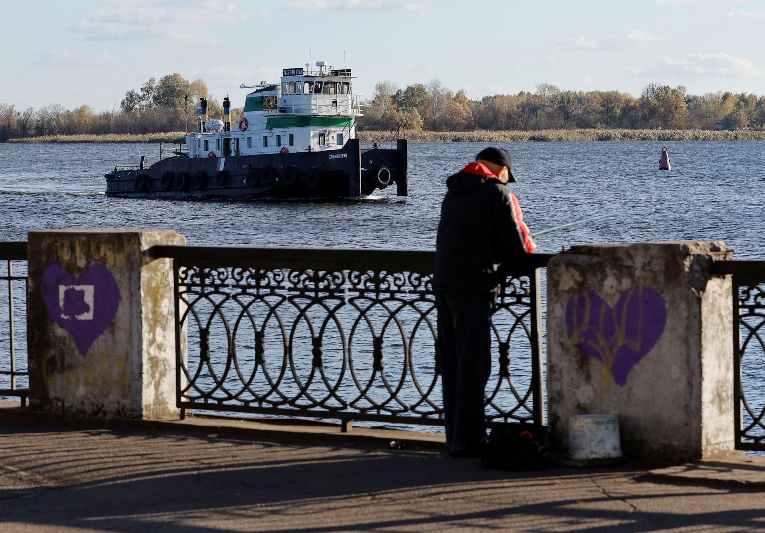 Mees püüab esmaspäeval Hersonis Dnepri jõe kaldal kala.